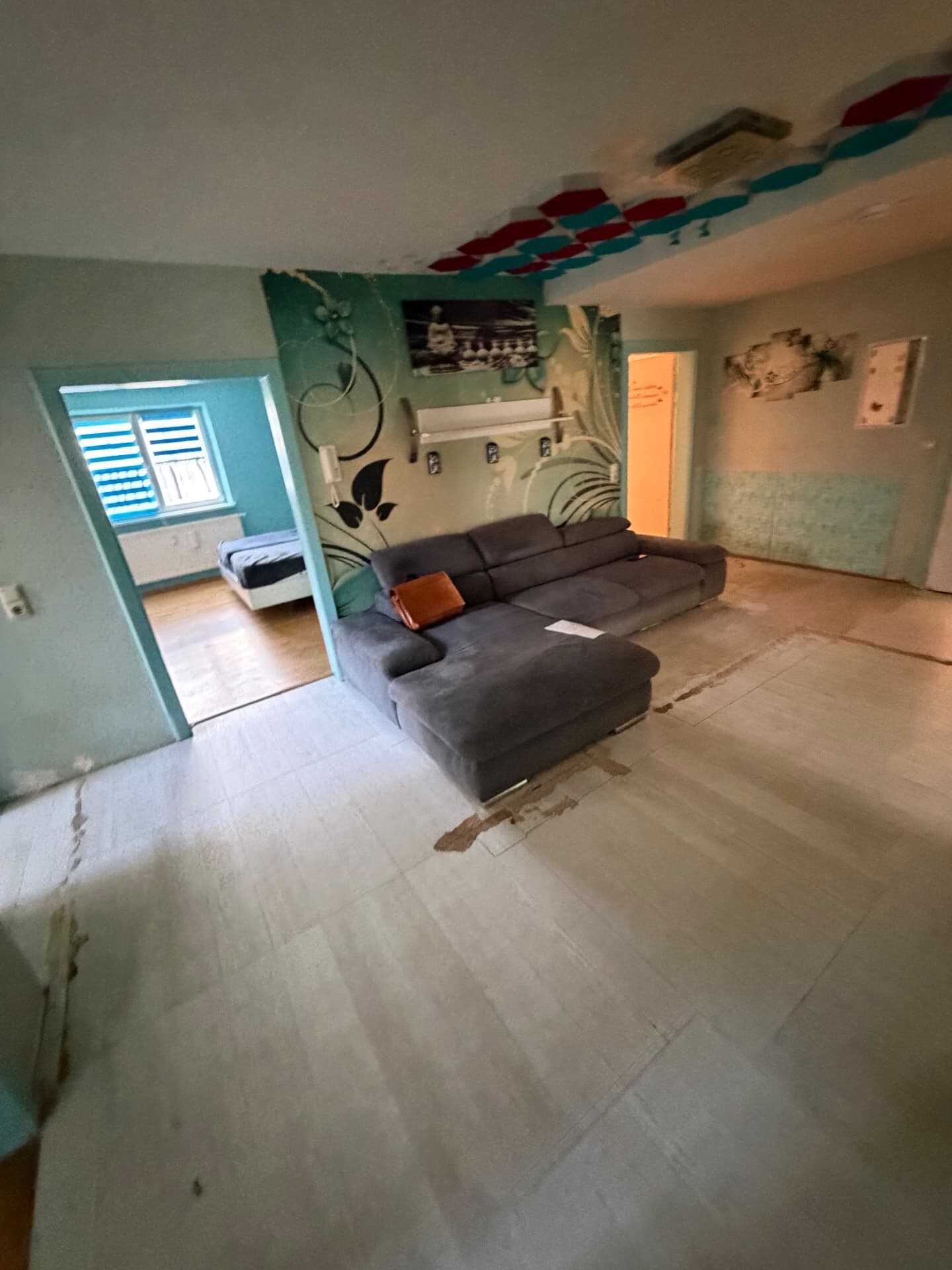 Vorher – Wohnzimmer mit altem Boden und farbigen Wänden